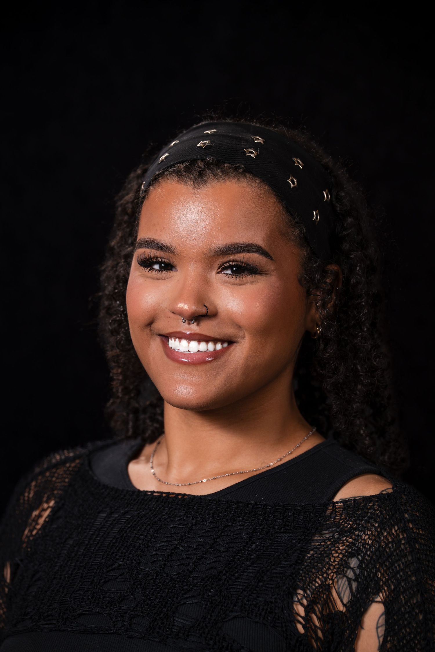 Professional portrait series against black background showing joyful expressions and curly hair in elegant black attire.