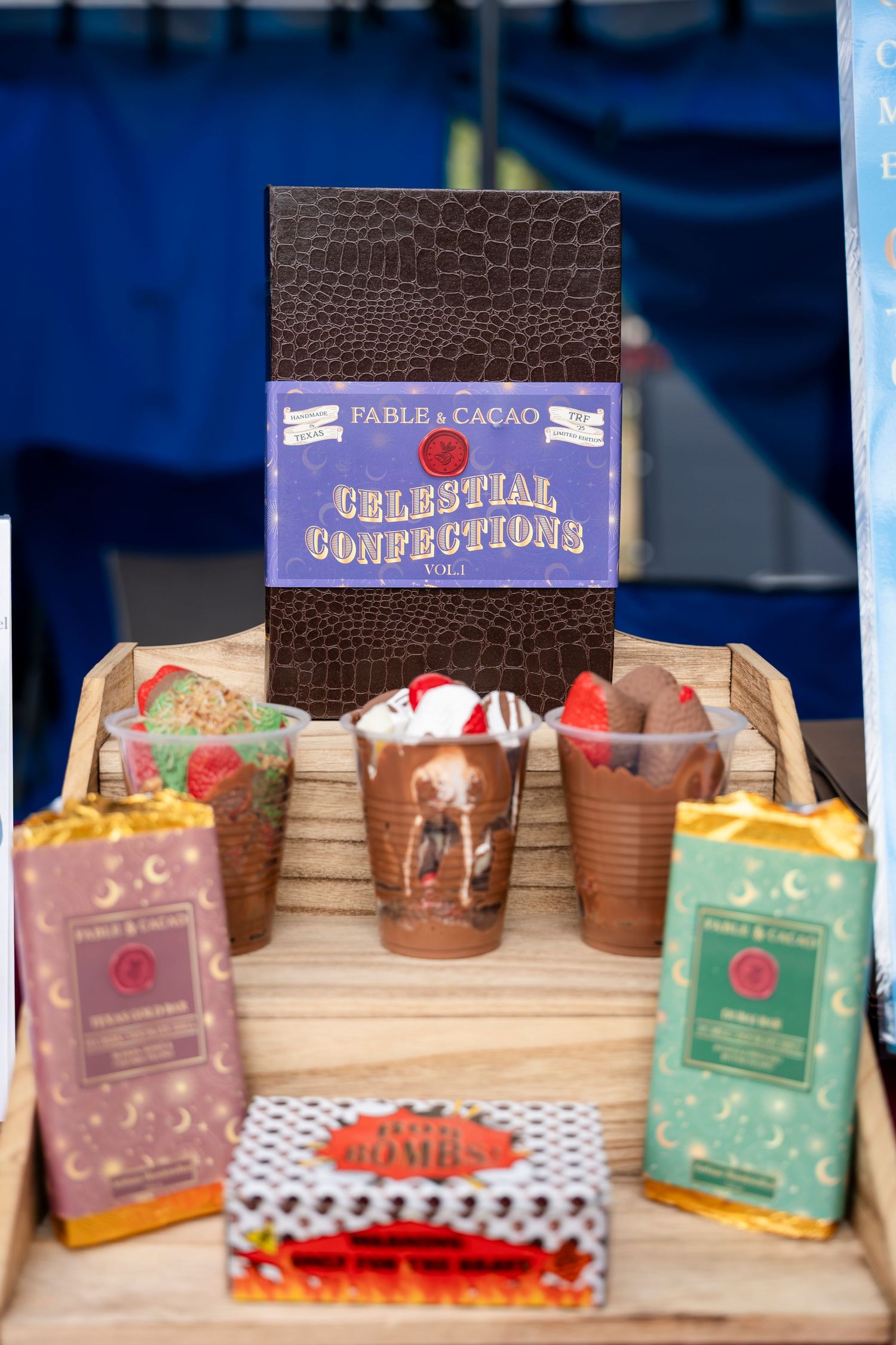 A chocolate themed display featuring confections, drinks and a brown leather-textured book on a wooden surface.