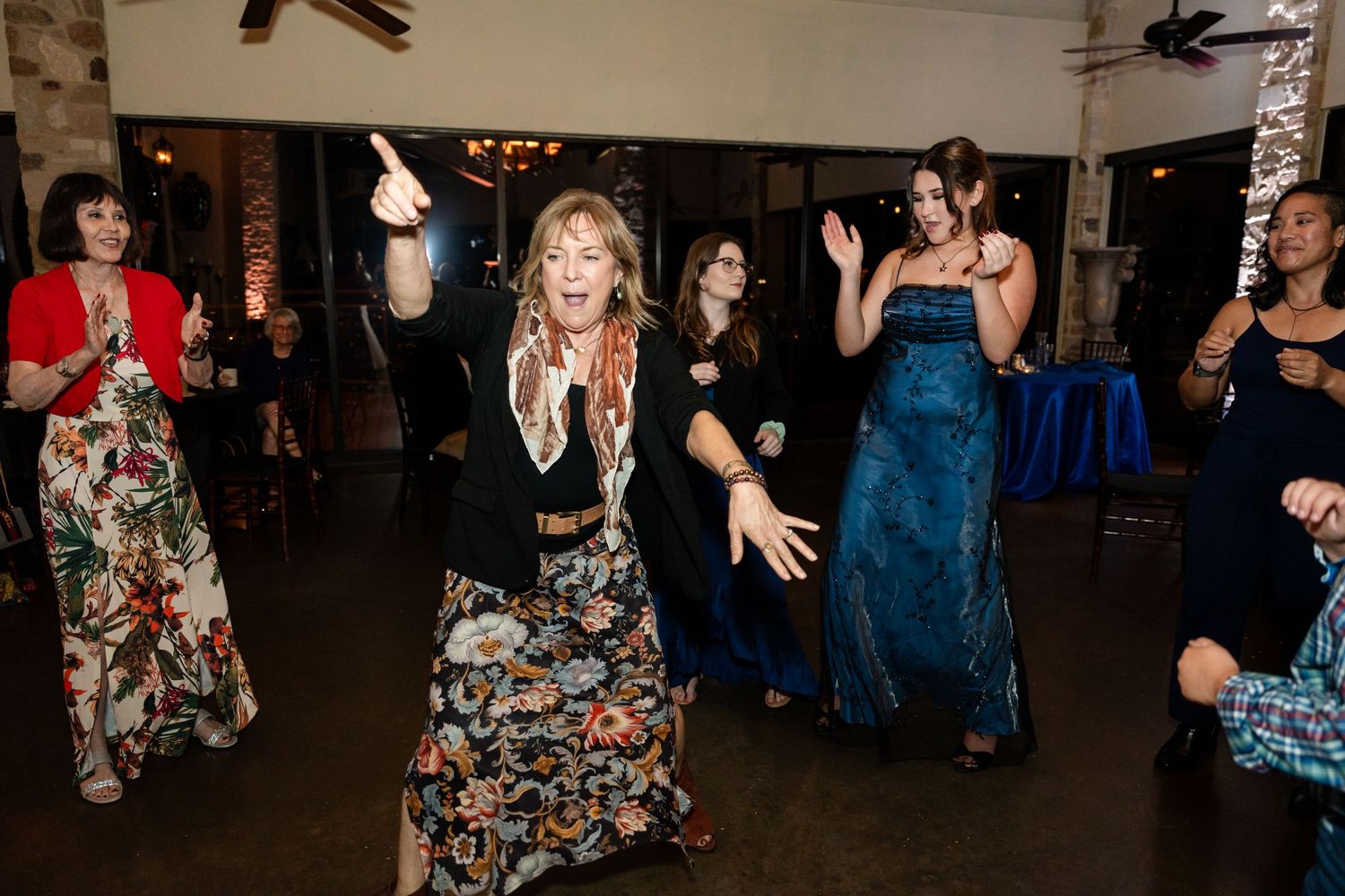 Party guests dancing and having fun during an indoor celebration with mood lighting.