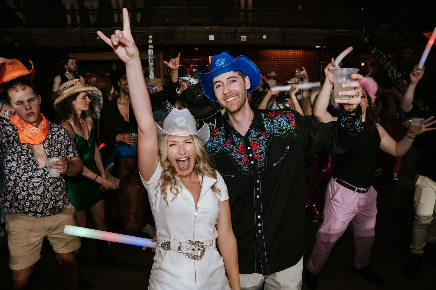 Festive party crowd dancing and celebrating at a nighttime event.