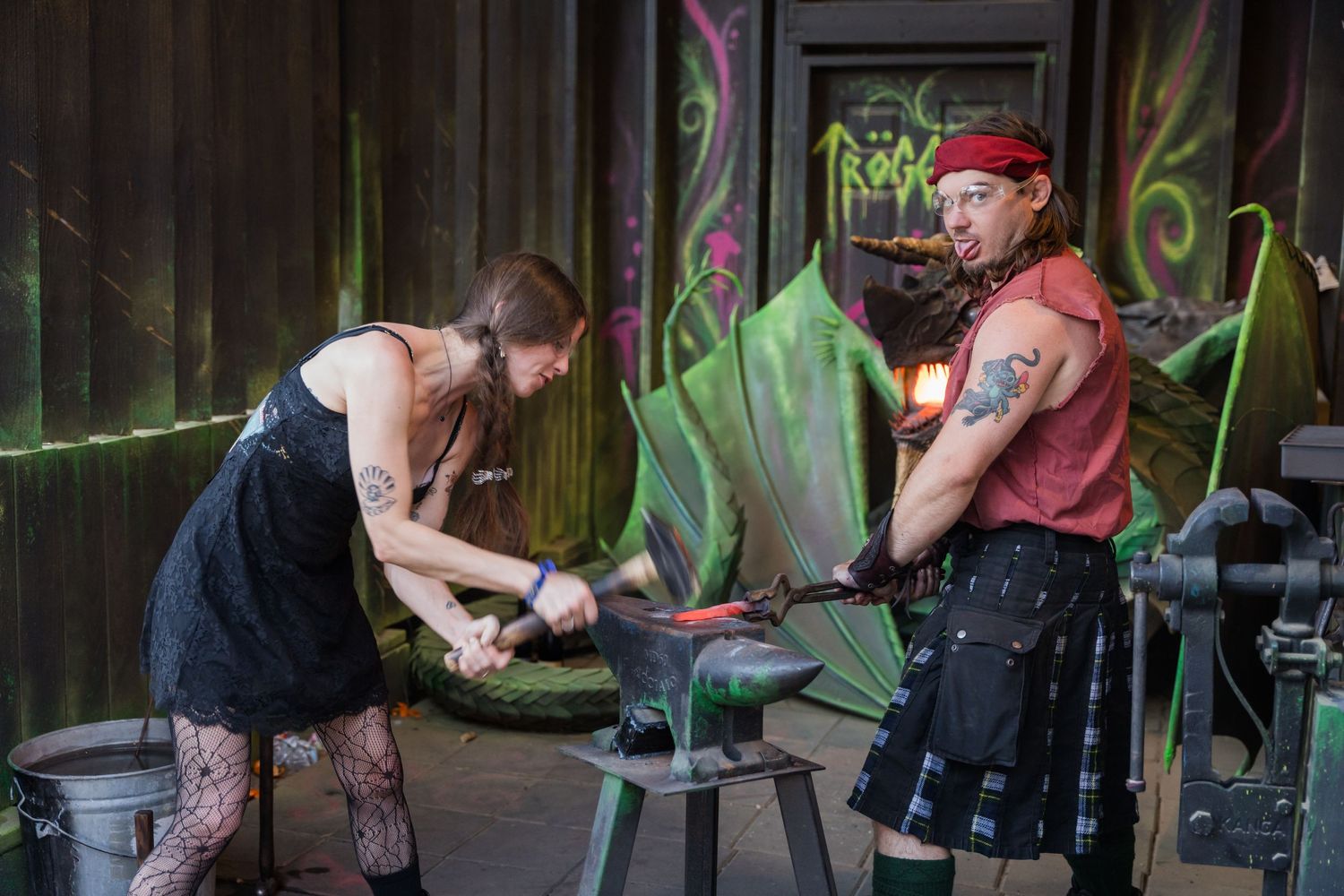 Blacksmiths working at an outdoor forge during a Renaissance festival demonstration.