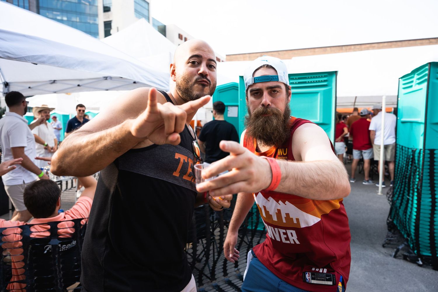Two enthusiastic fans making gestures at a sports event.