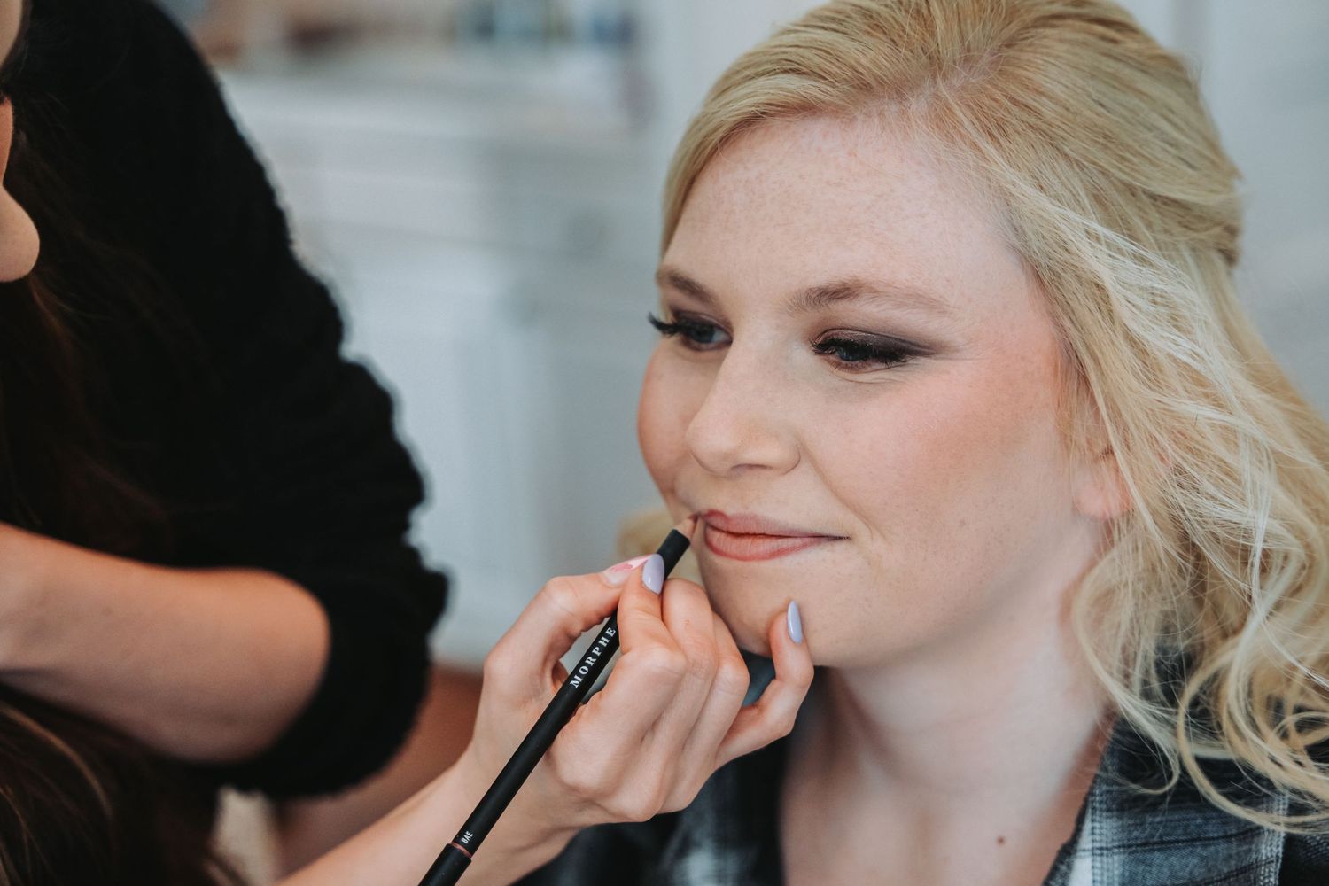 Behind the scenes makeup application during wedding preparation.