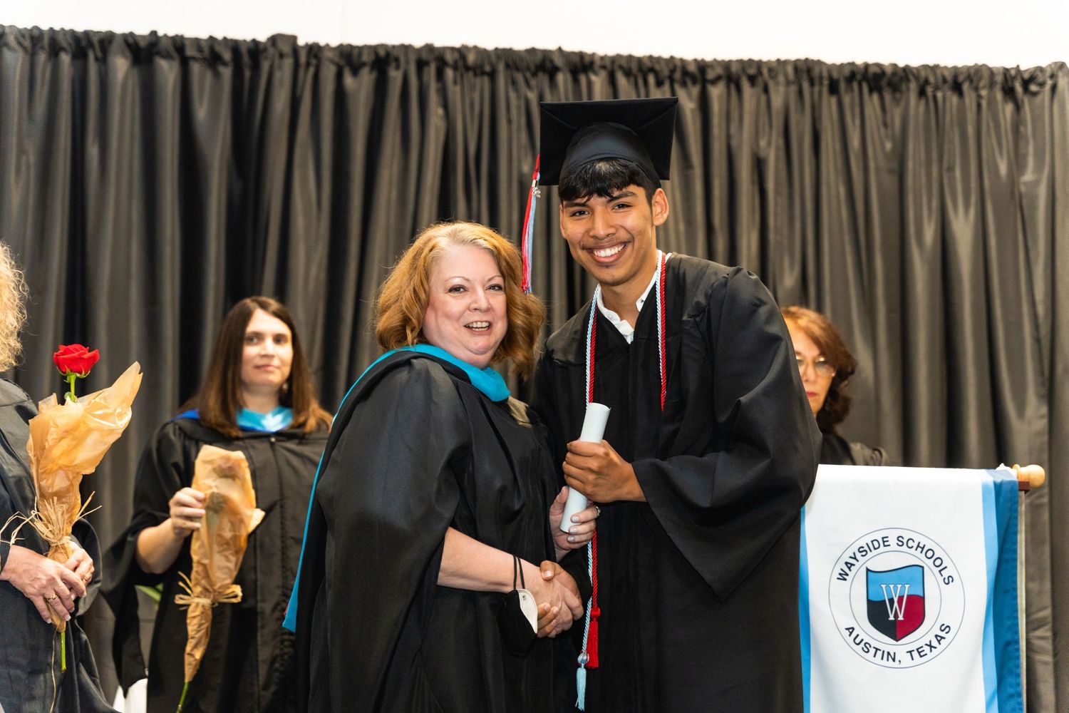 Graduates in caps and gowns celebrate during a university commencement ceremony.