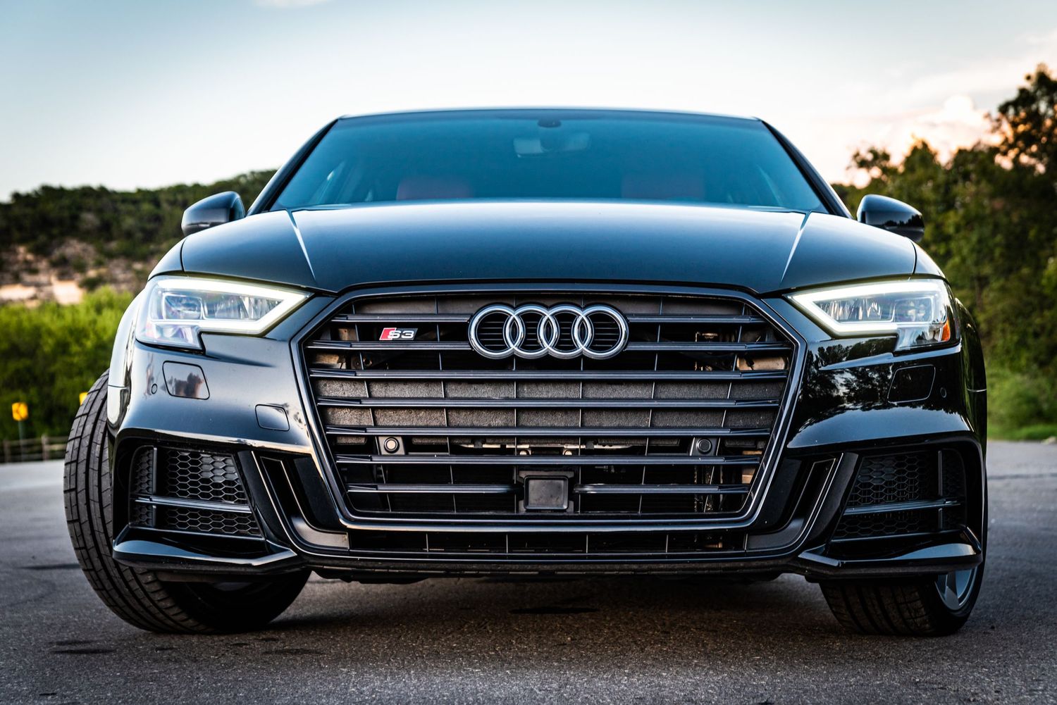 Close up front view of black Audi S3 showing detailed honeycomb grille and LED headlights.