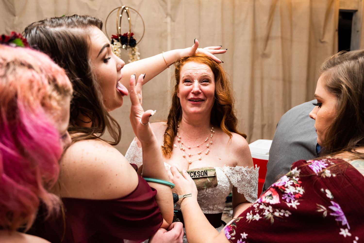Wedding guests laugh and celebrate during a festive reception moment.