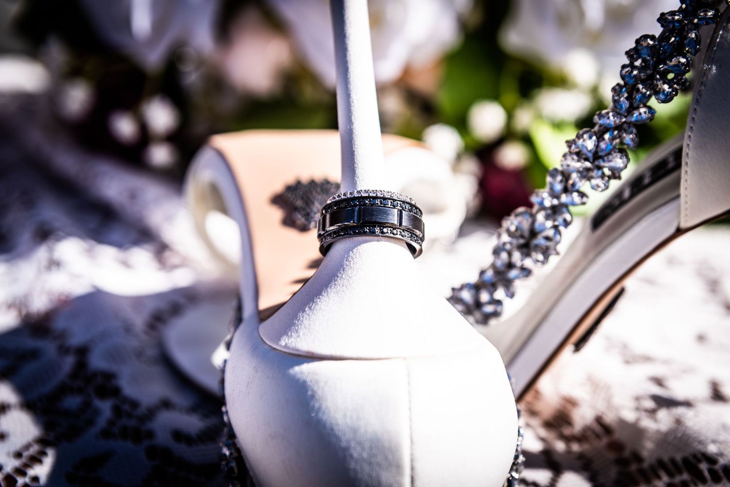 Close-up of an ornate white bridal shoe with sparkly decorative elements.