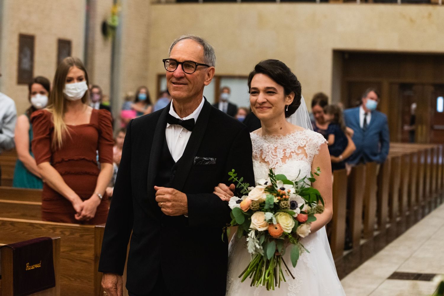 An elegant church wedding ceremony with a bouquet of blush roses and lace details.