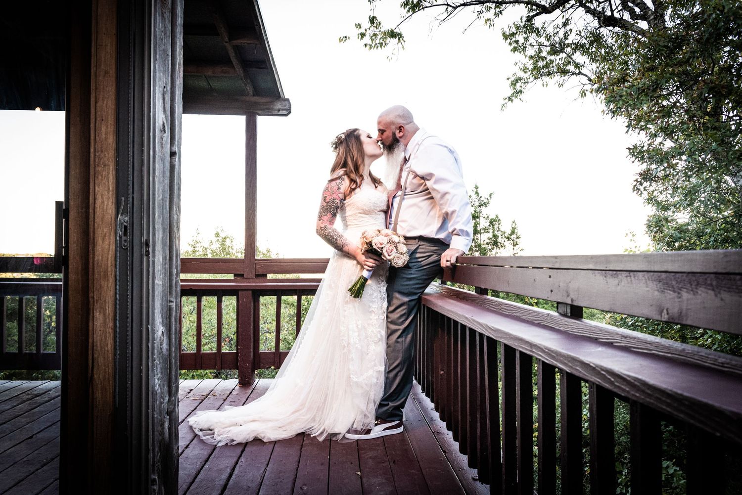 A romantic moment captured on a wooden deck with scenic natural backdrop.