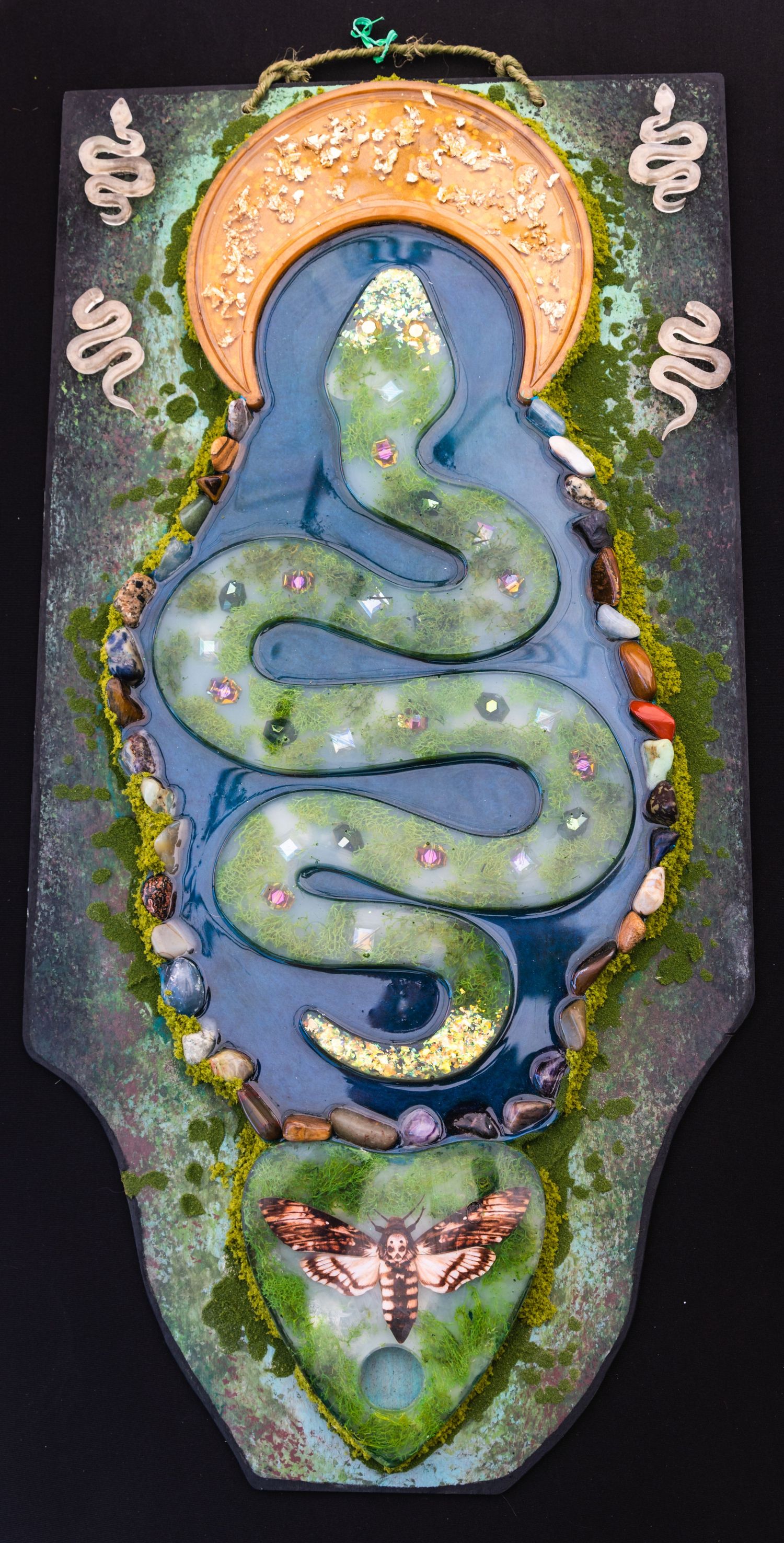 Artistic wall hanging featuring a serpentine design with mystic and nature elements.