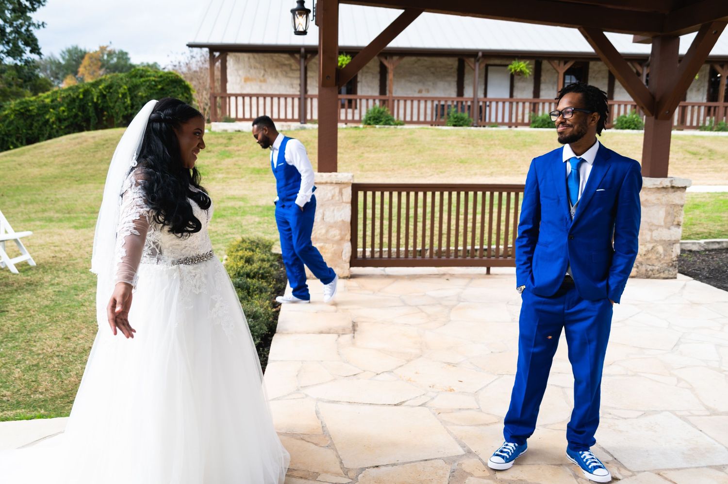 A couple shares their first look moment under a covered patio during an outdoor wedding ceremony.
