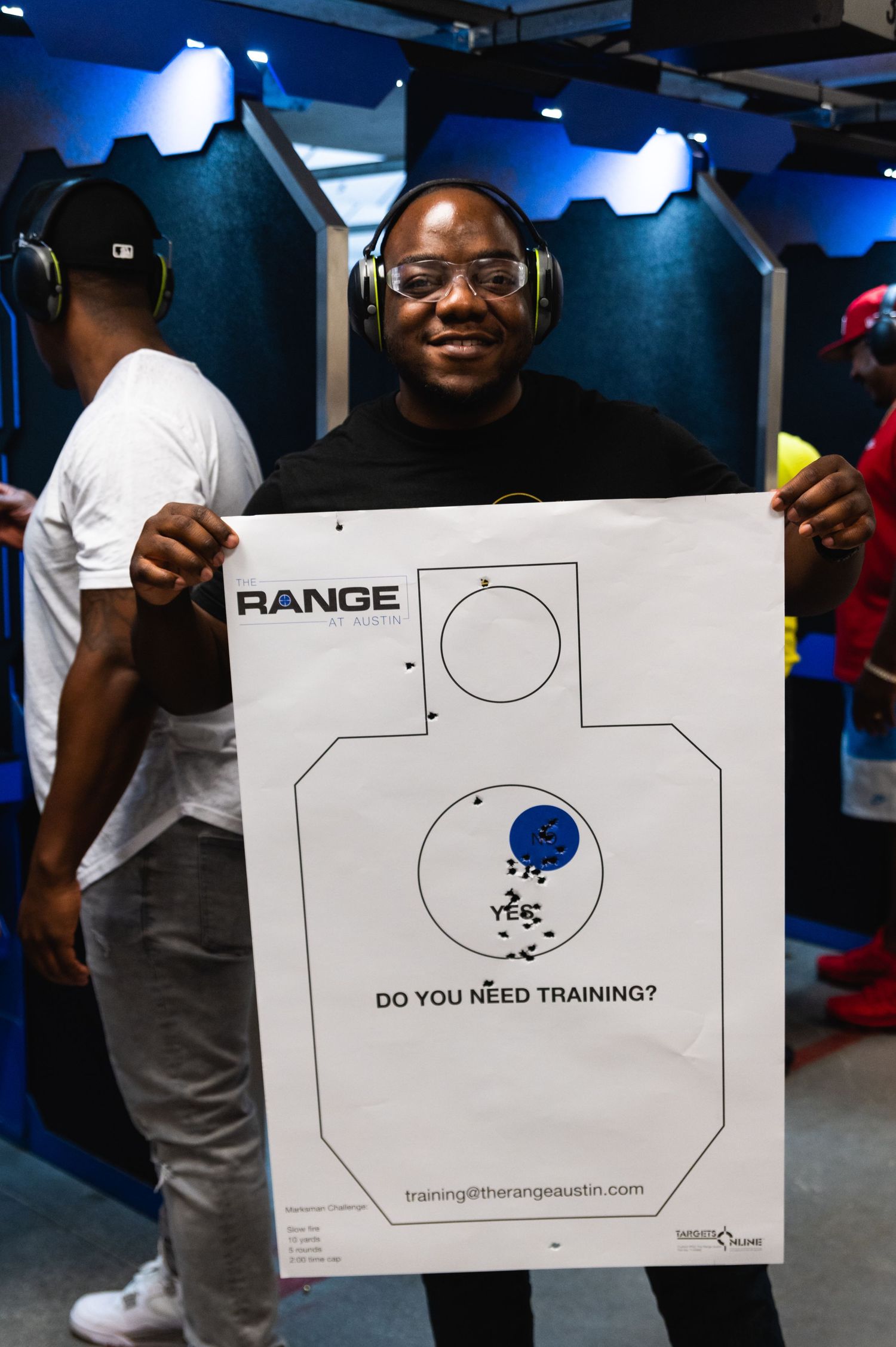 Individual displaying target practice sheet at indoor shooting range facility.