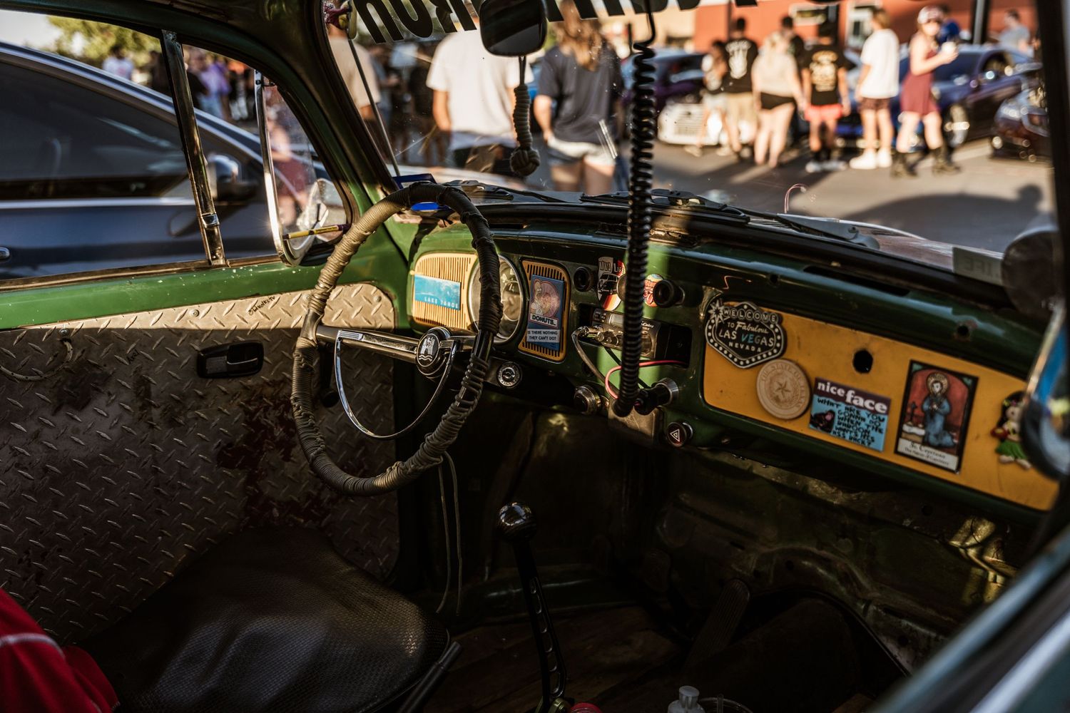 Interior dashboard view of a classic Volkswagen Beetle showing vintage steering wheel and gauges.