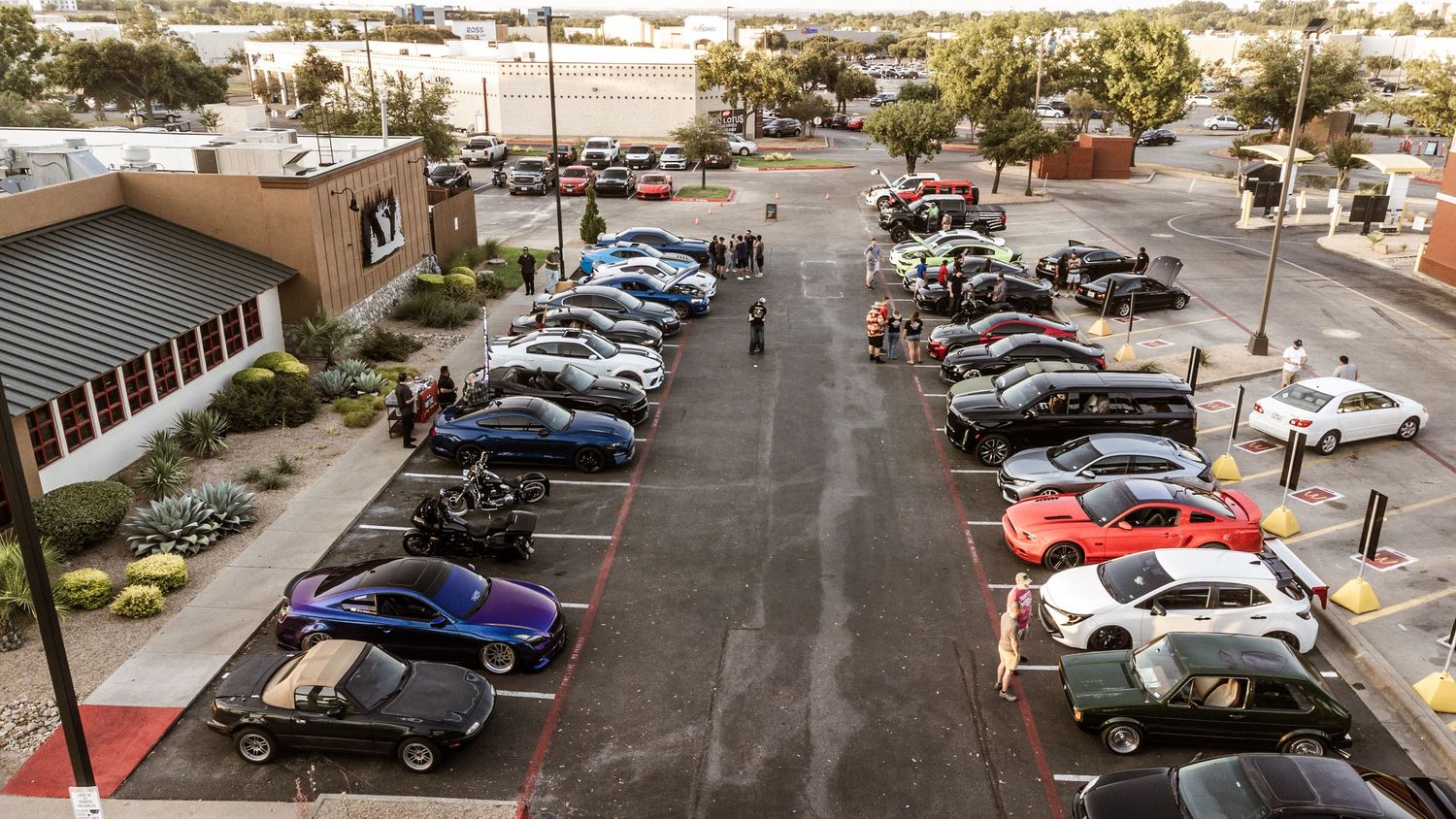 Overhead view of cars parked in a commercial parking lot.