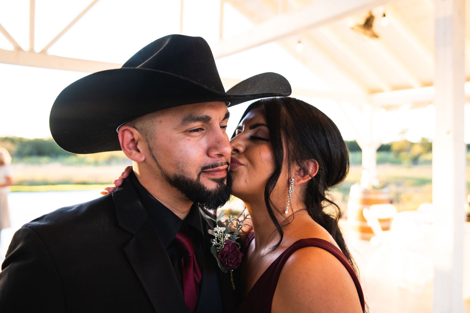 A romantic moment between a couple at an outdoor wedding reception.
