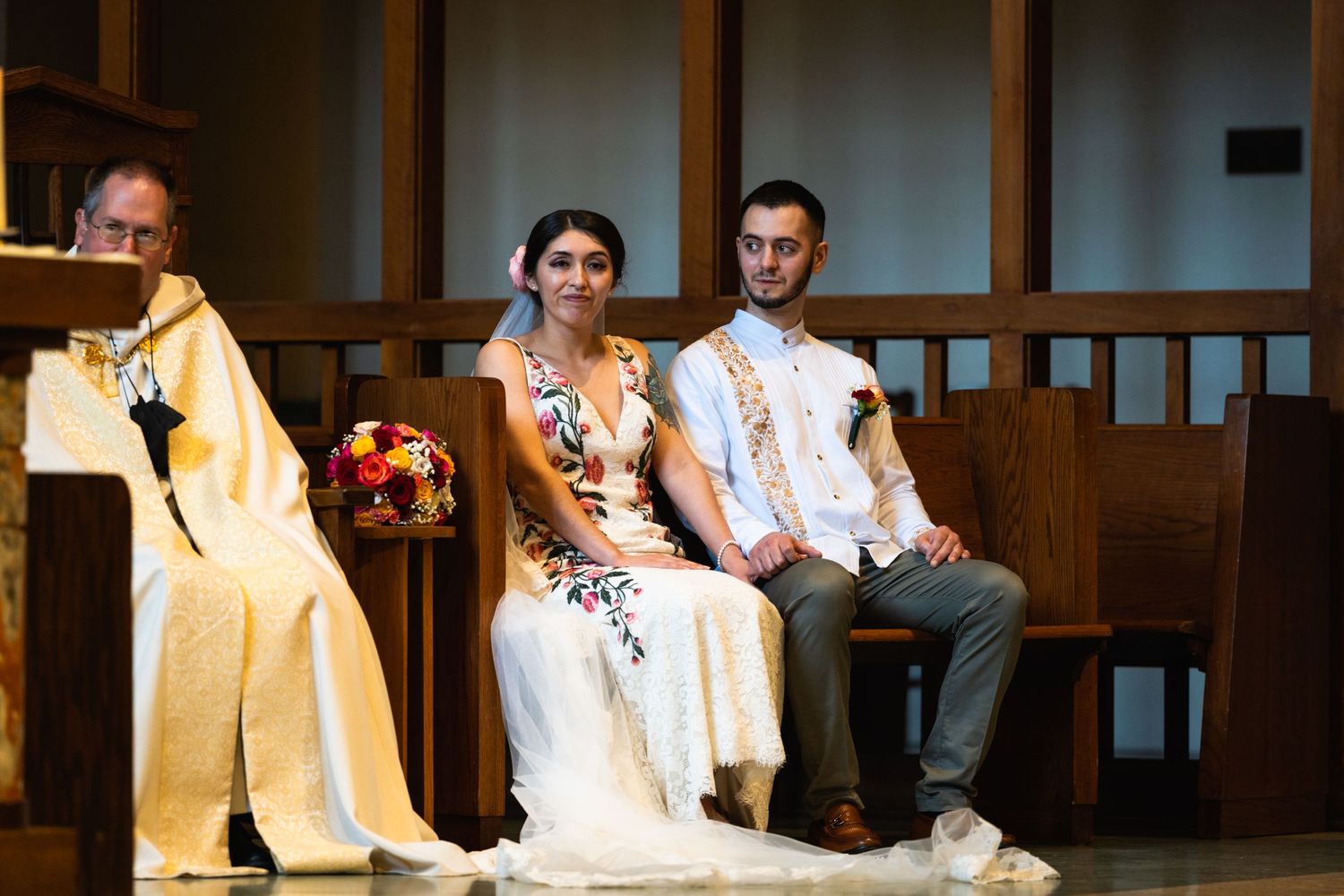 Wedding ceremony in traditional church setting with ornate decorations.