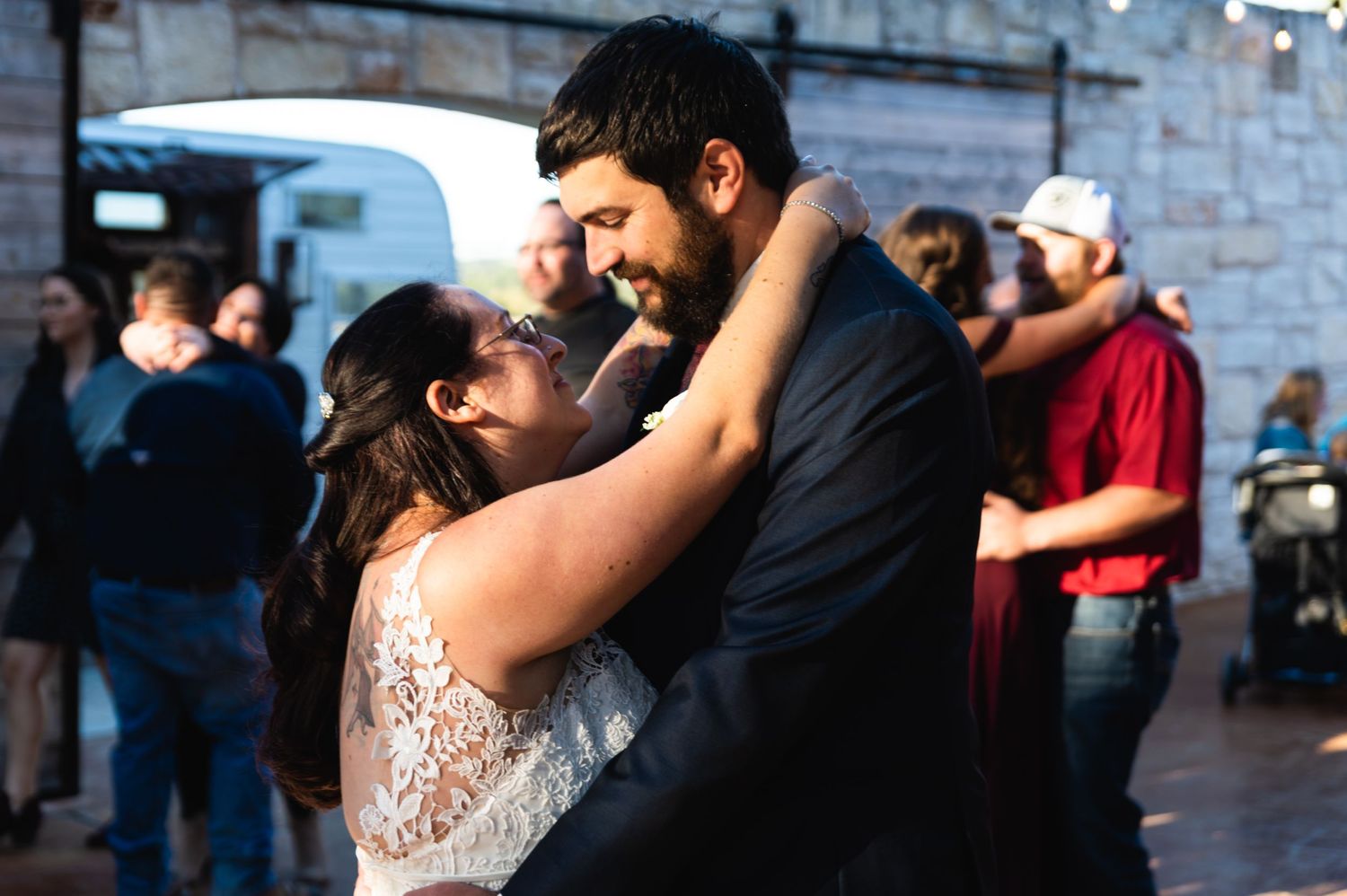 A tender embrace shared between newlyweds during their wedding dance outdoors.