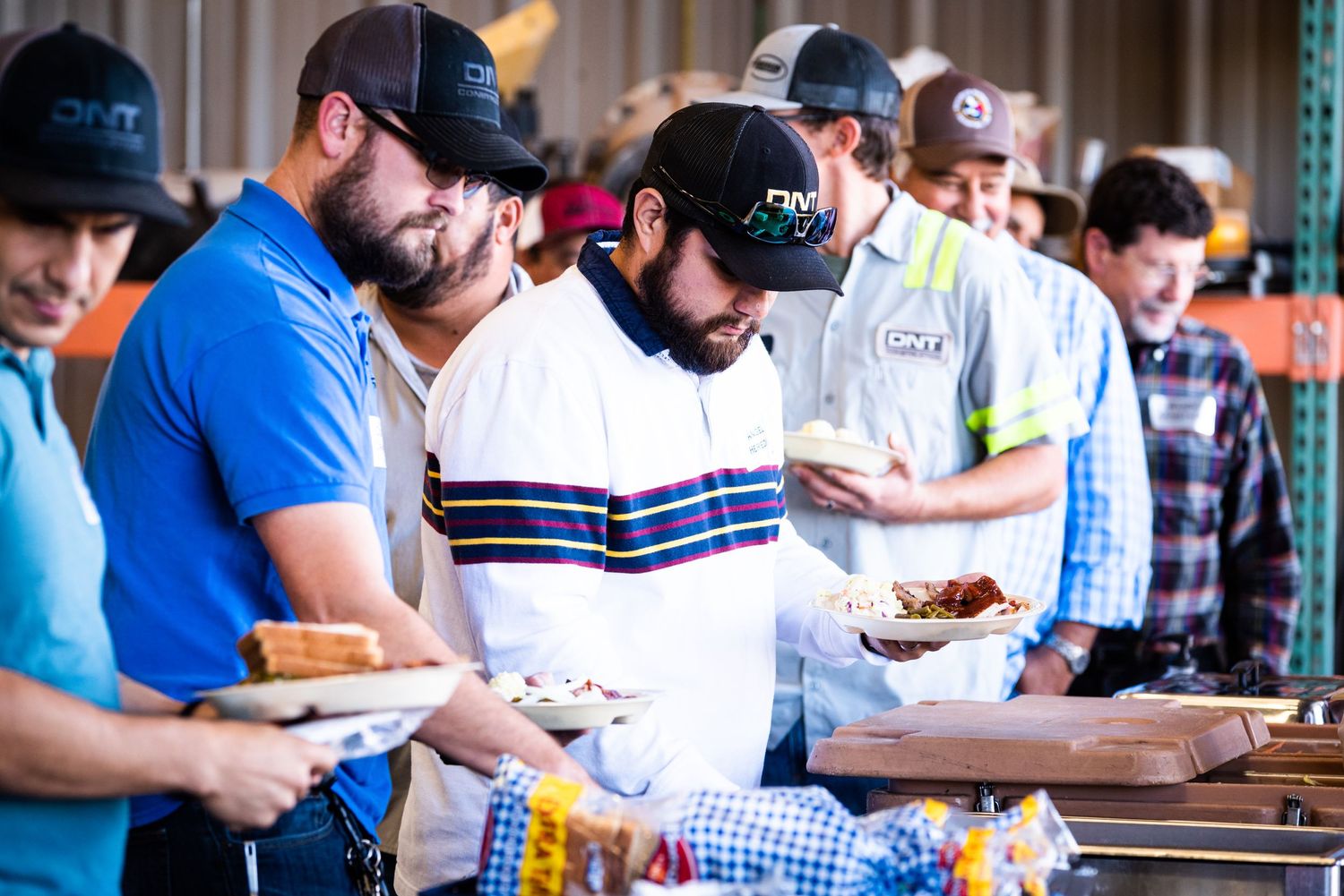 Line of people at a buffet table serving themselves food.
