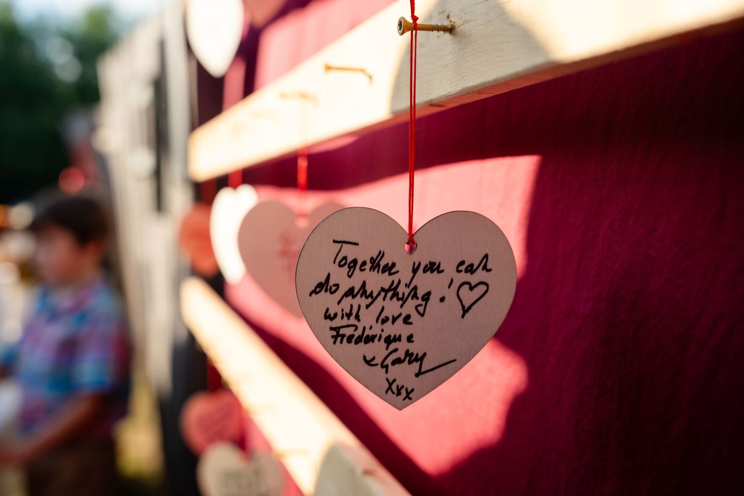 A handwritten heart-shaped note hanging on display.