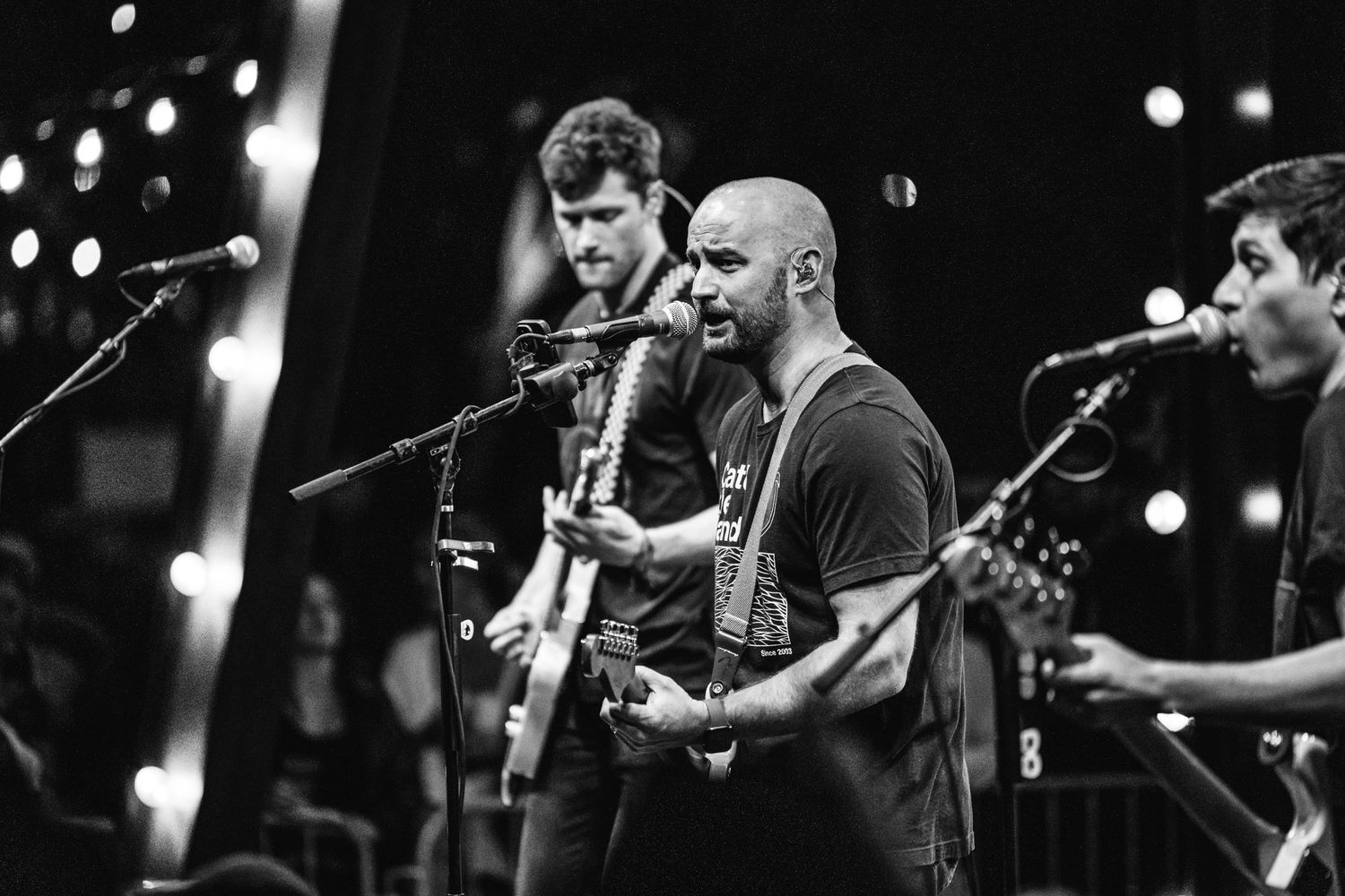 Black and white photo of band performing on stage with string instruments.