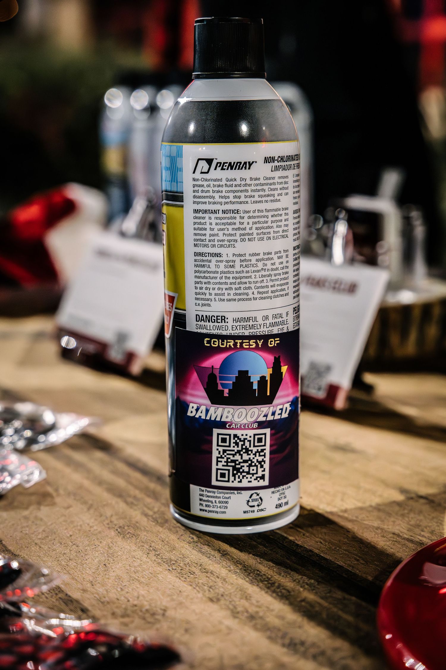 Close-up shot of an aerosol product bottle with QR code displayed on wooden surface.