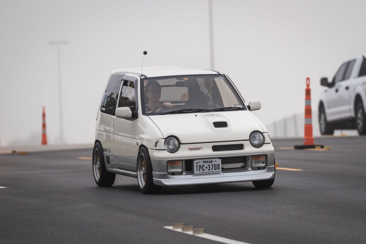 Modified silver Suzuki Alto Kei car with custom body kit and wheels.
