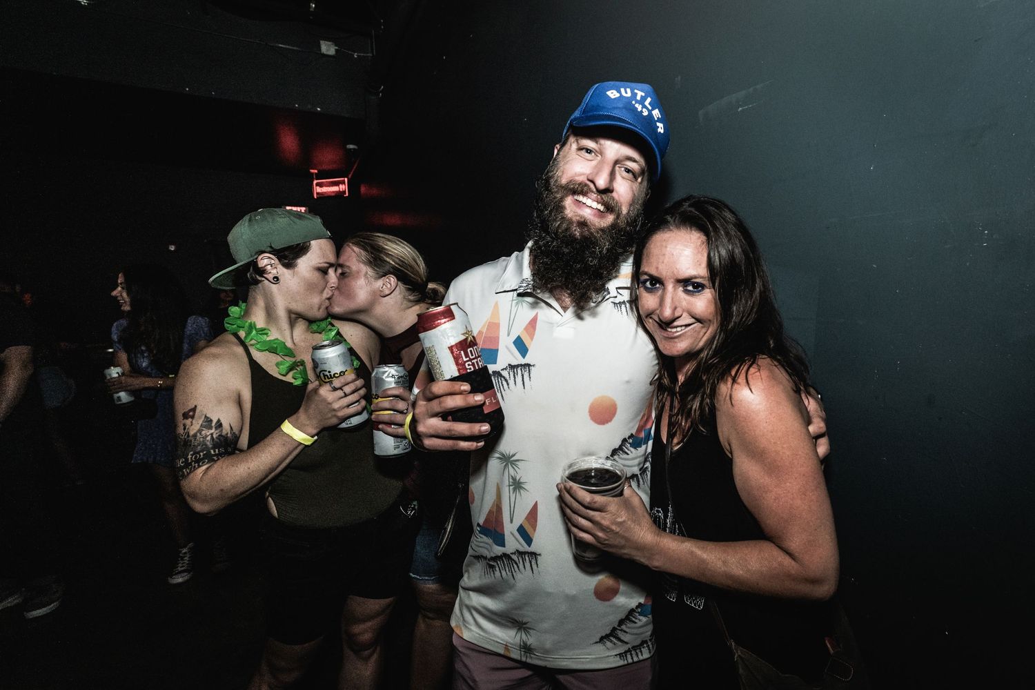 Concert goers enjoying drinks and socializing at music venue.