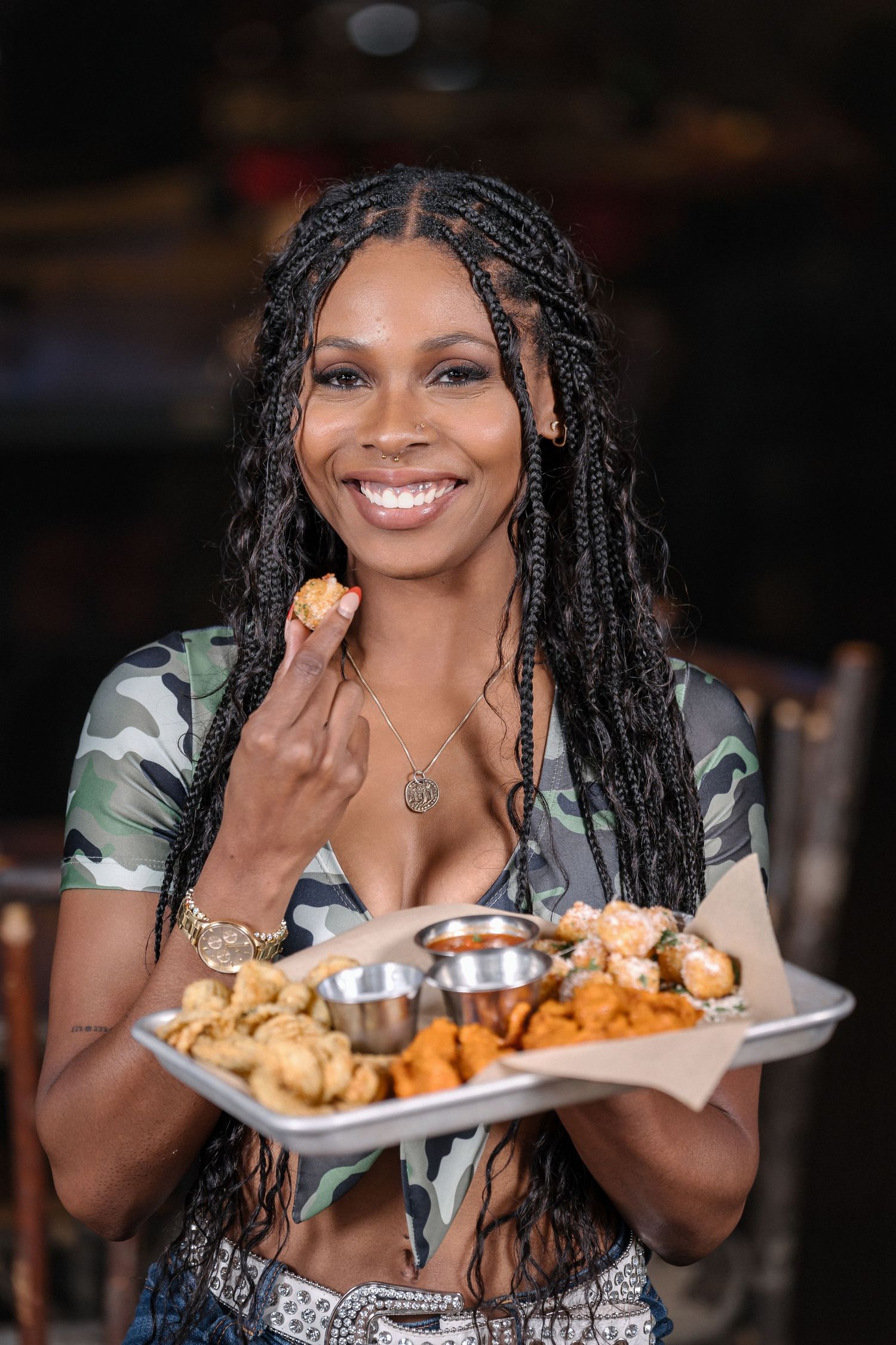 Restaurant server enjoying appetizers while wearing camouflage crop top.