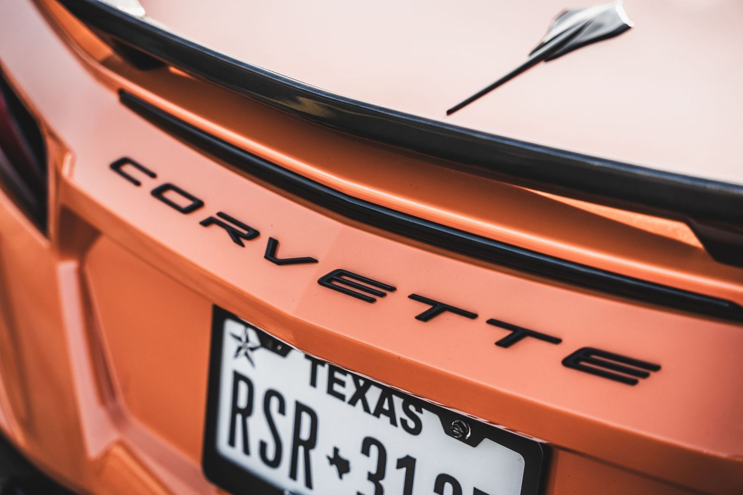 Close-up of orange Corvette badge and Texas license plate.