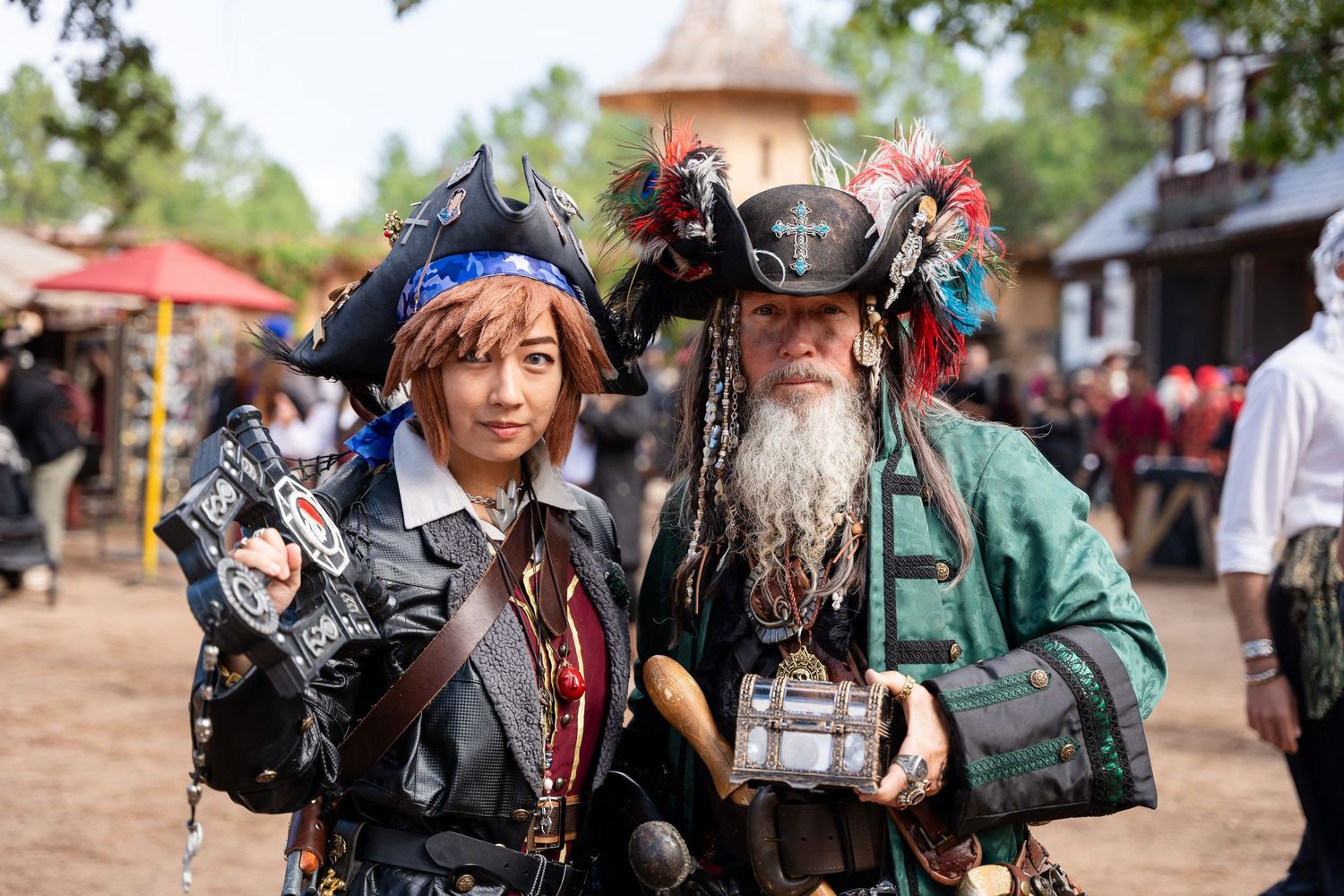 Medieval cosplayers in ornate costumes and armor gather at a renaissance fair event.