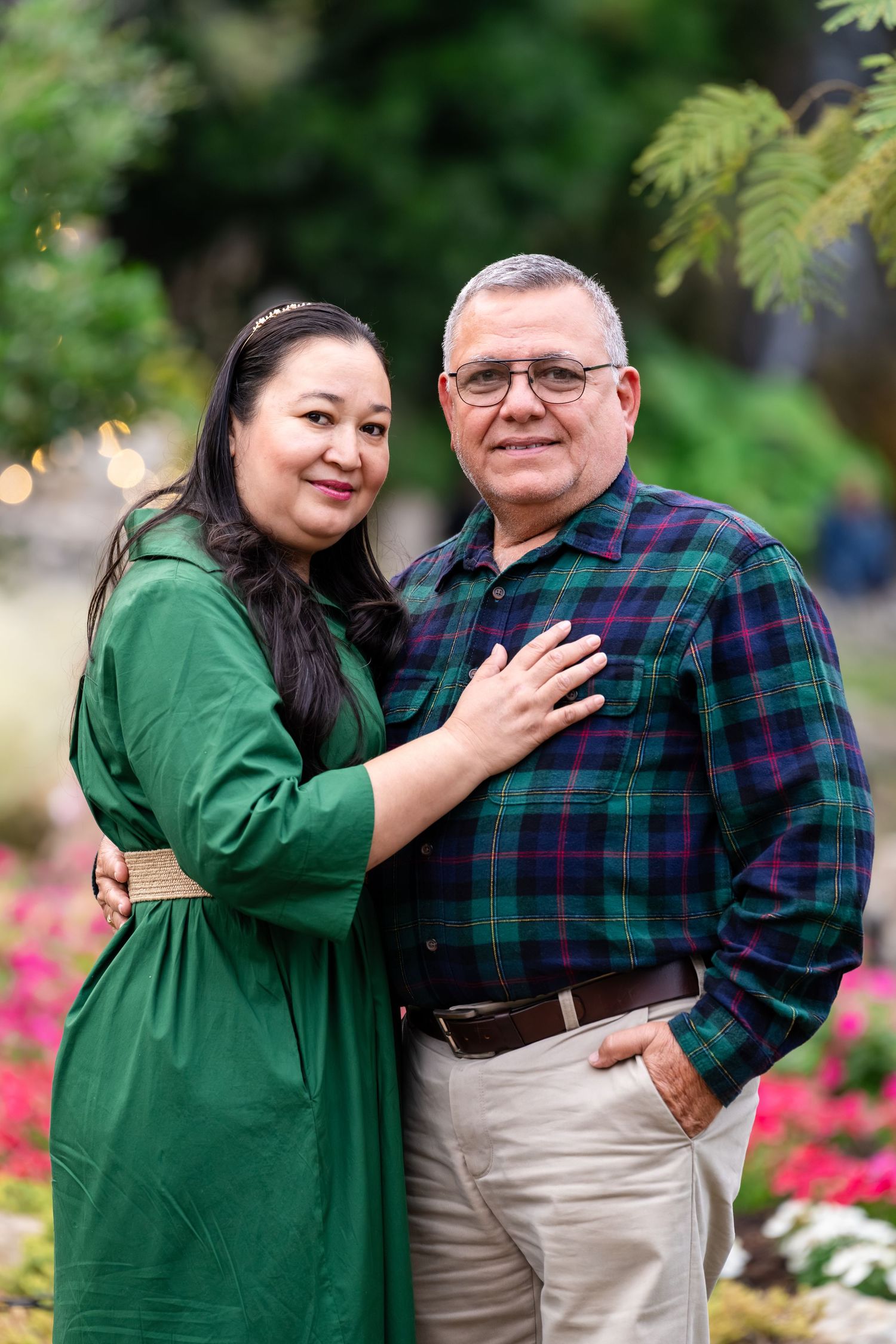 A series of candid photos showing a woman in green and a man in plaid sharing affectionate moments in a garden setting.