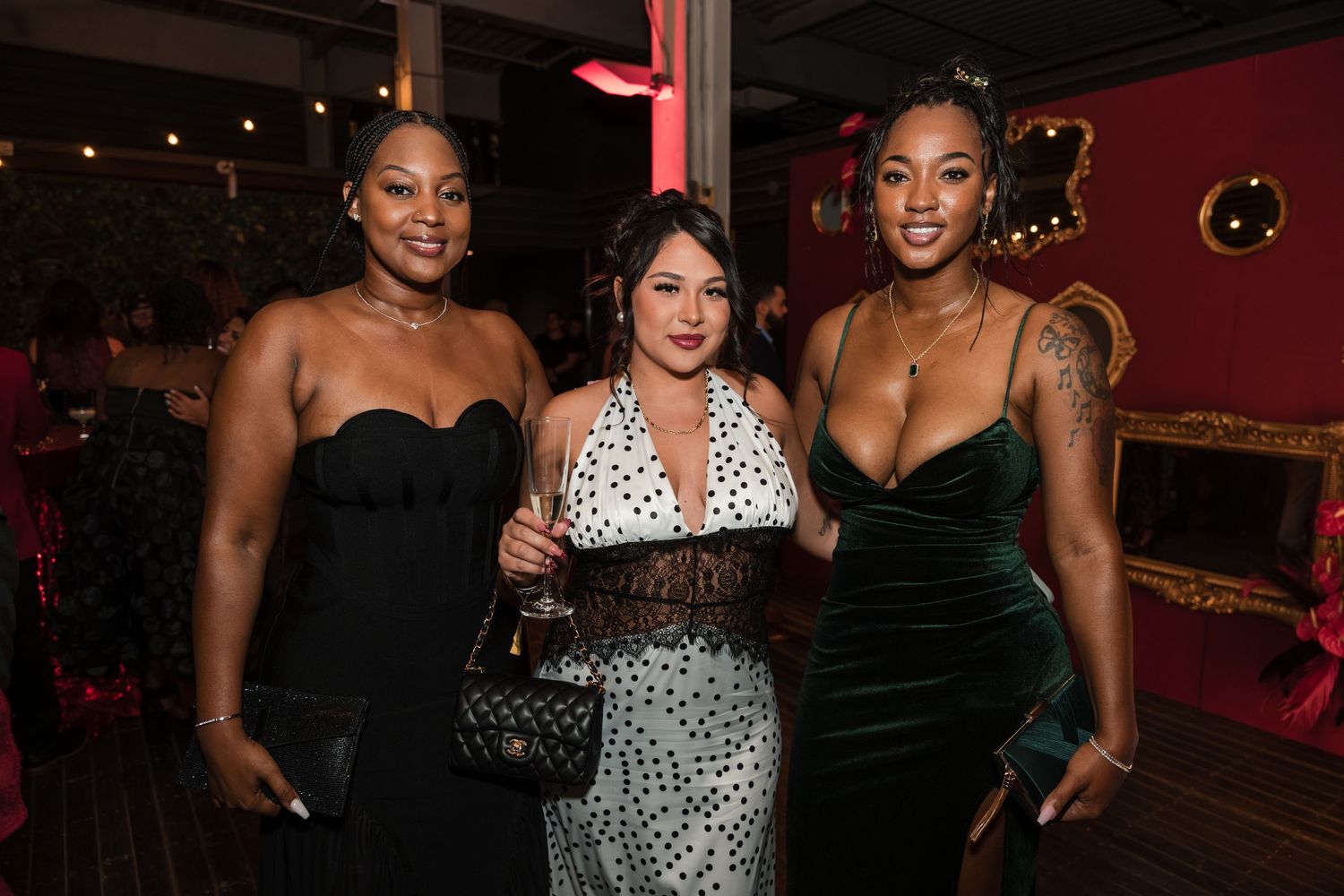 People enjoying a night out at a bar with red lighting and dark ambiance.