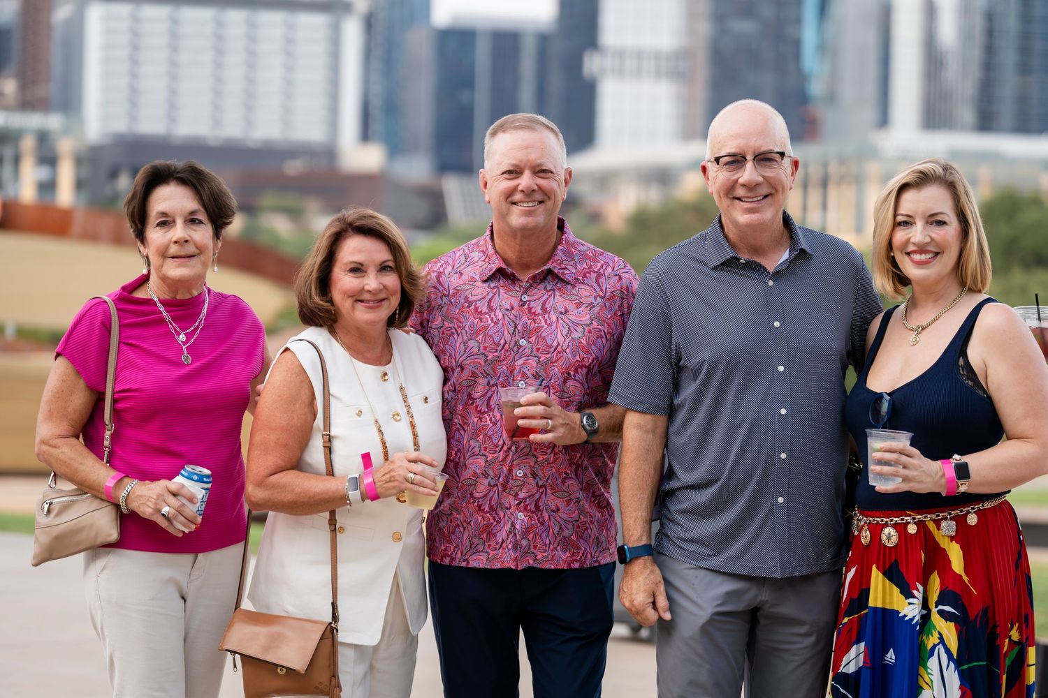 A group of people gathered outdoors for a social event, smiling and posing together in casual attire.