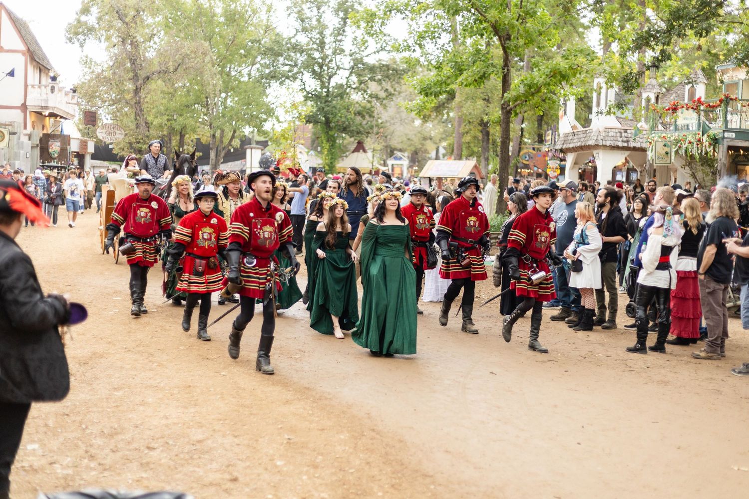 A large crowd gathers outdoors for a community event with people in red and dark colored uniforms visible.