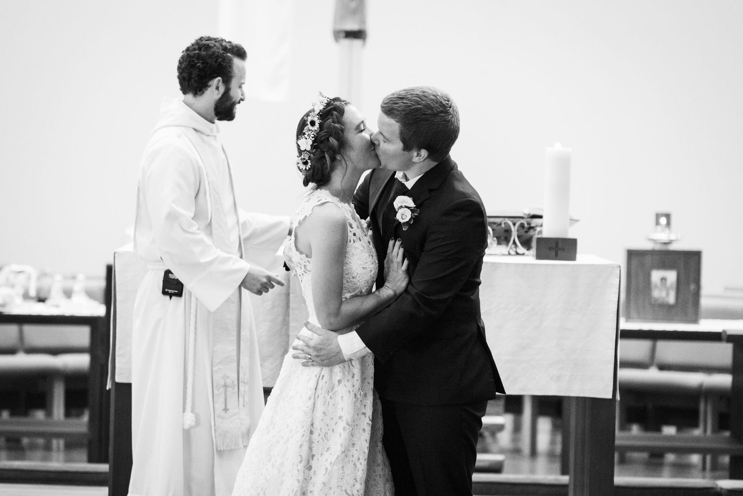 A couple shares a romantic moment at the altar during their traditional church wedding ceremony with minister present.