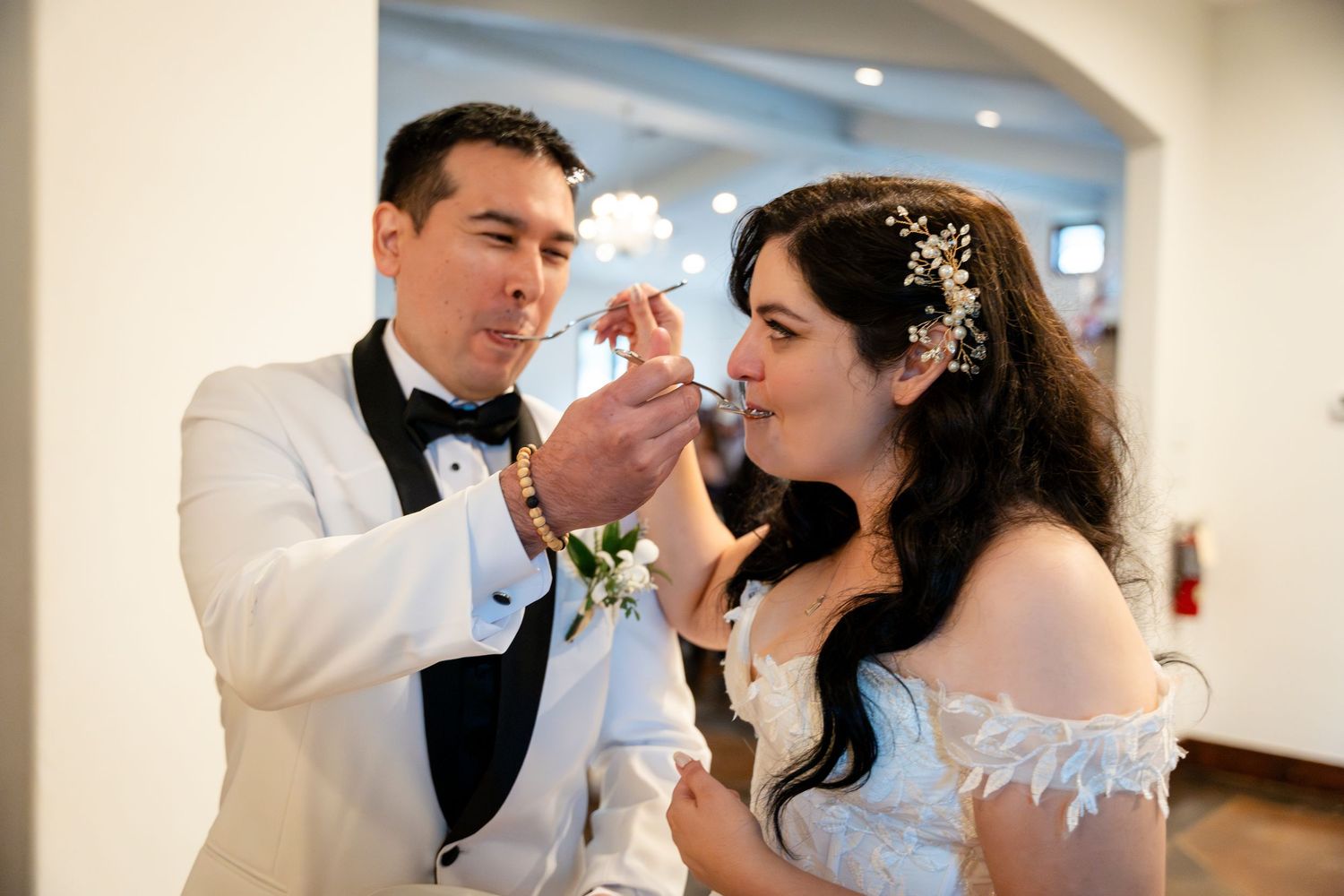A couple sharing a romantic dance at their wedding reception in an elegantly decorated indoor venue.