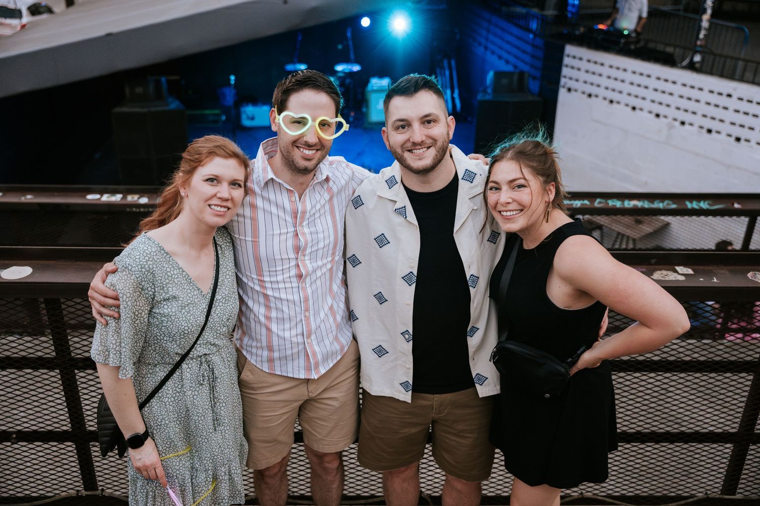 Friends gather for photo at nighttime venue with blue lighting.