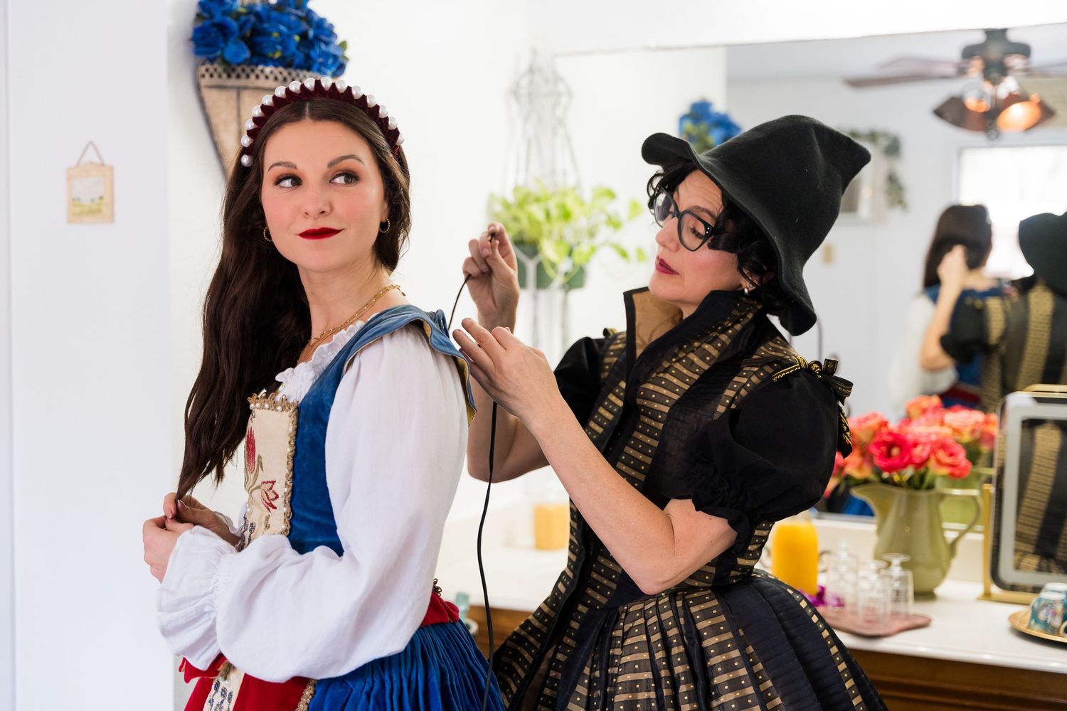 Two costumed performers interact during preparation at a renaissance fair.