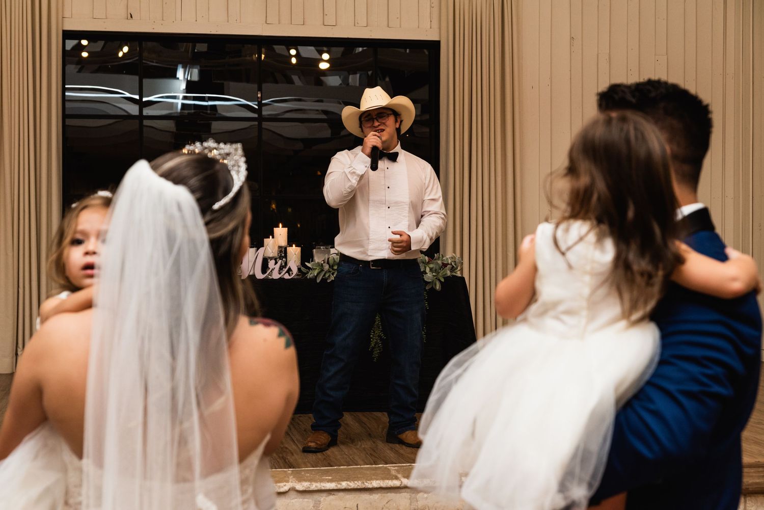 A wedding reception dance floor scene with a performer in a cowboy hat.