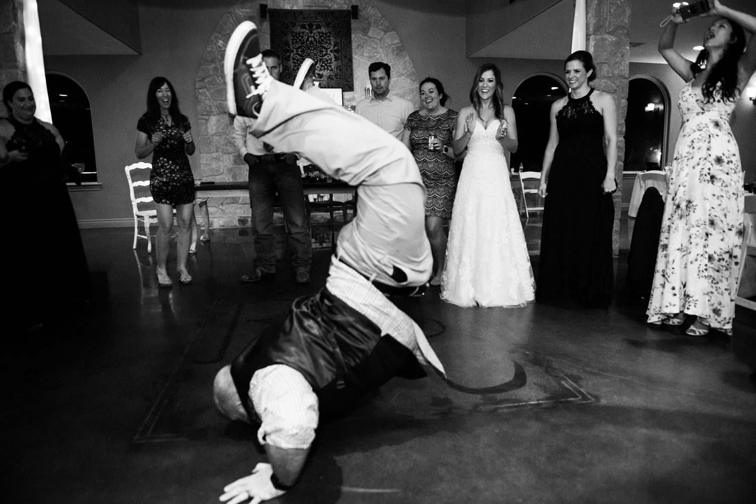 Guest performs an impressive breakdancing move on the wedding reception dance floor.