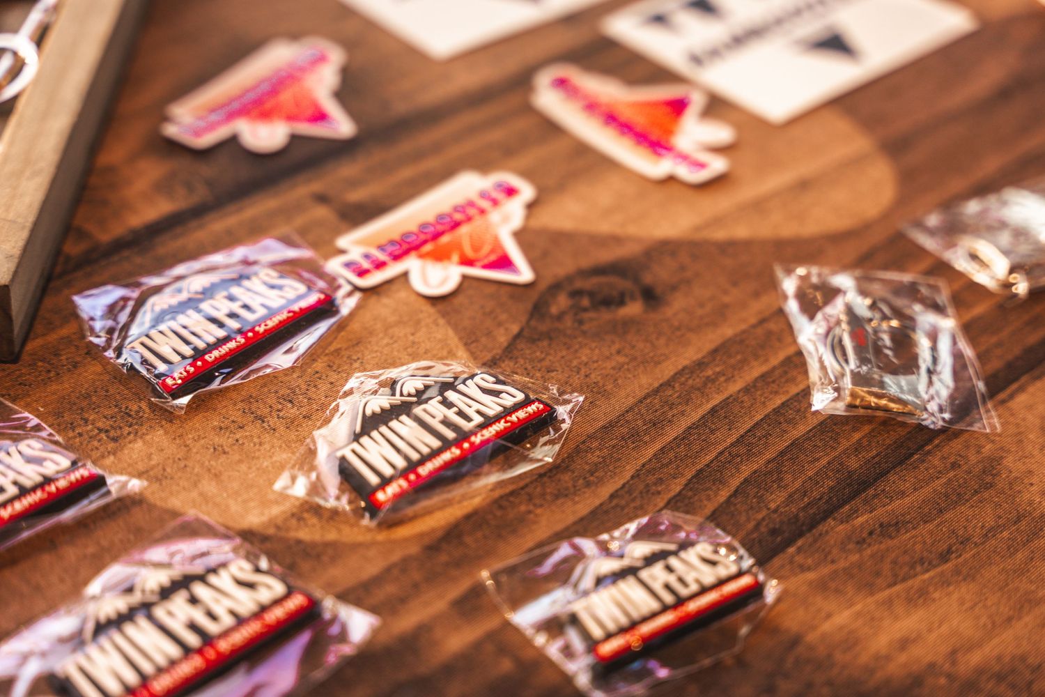 Collection of automotive-themed pins and stickers displayed on a wooden surface.