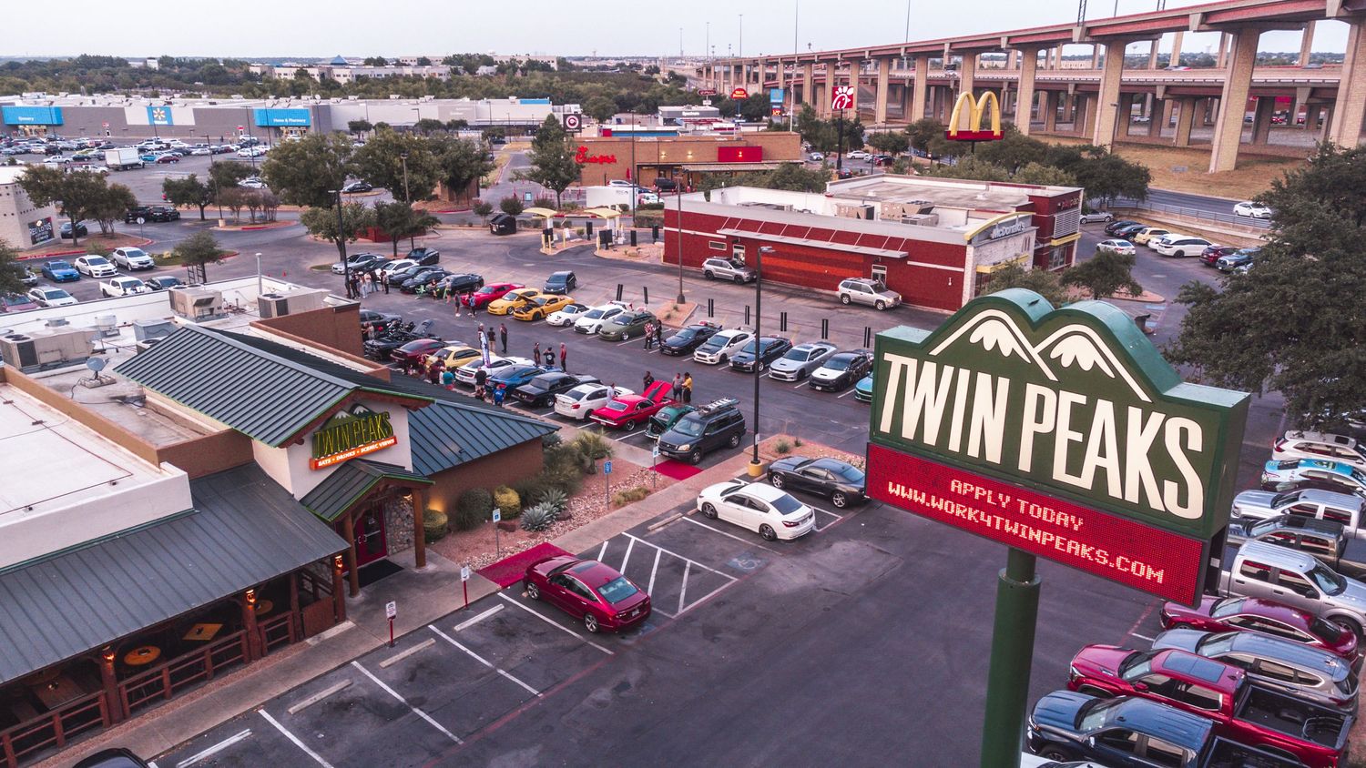 Aerial view of Twin Peaks restaurant parking lot filled with cars.
