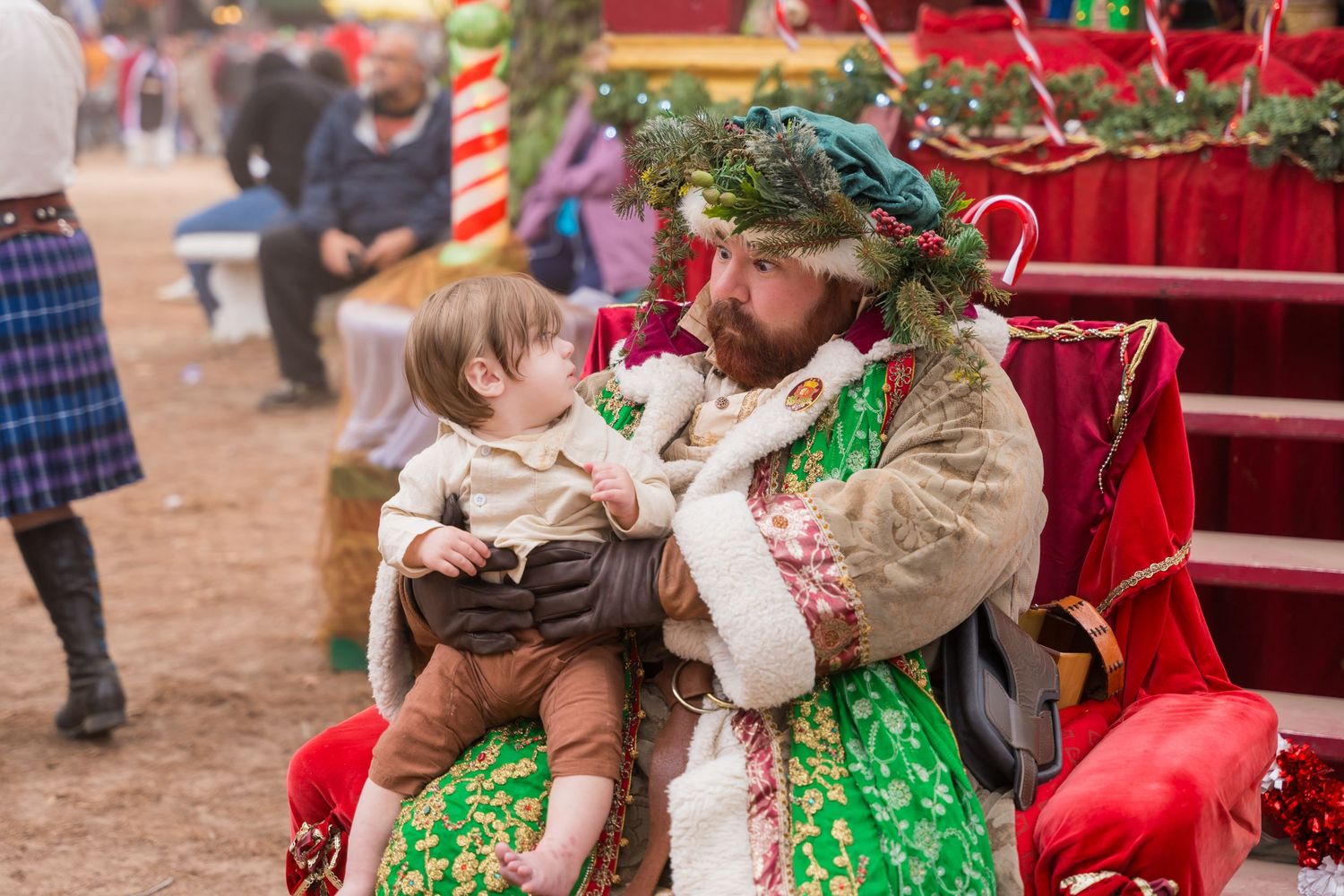 Festive holiday scene with costumed performers interacting with young visitors.