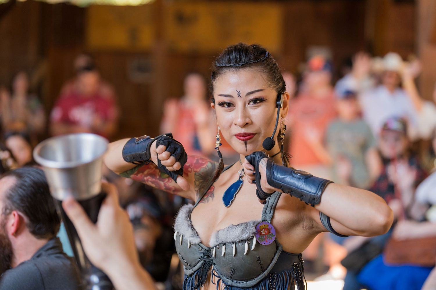 A performer in medieval armor costume poses dramatically during a festival show.
