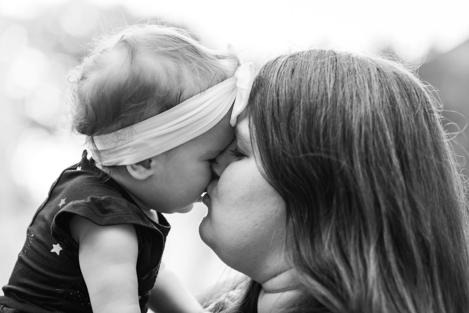 A tender moment captured in black and white of a loving kiss exchange.