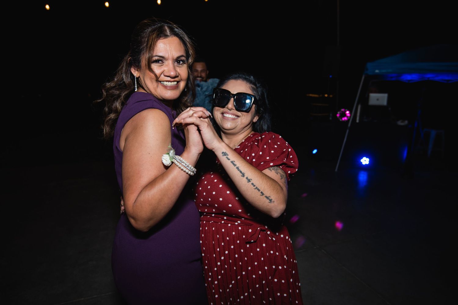 Two party guests pose together on the dance floor during a celebration.