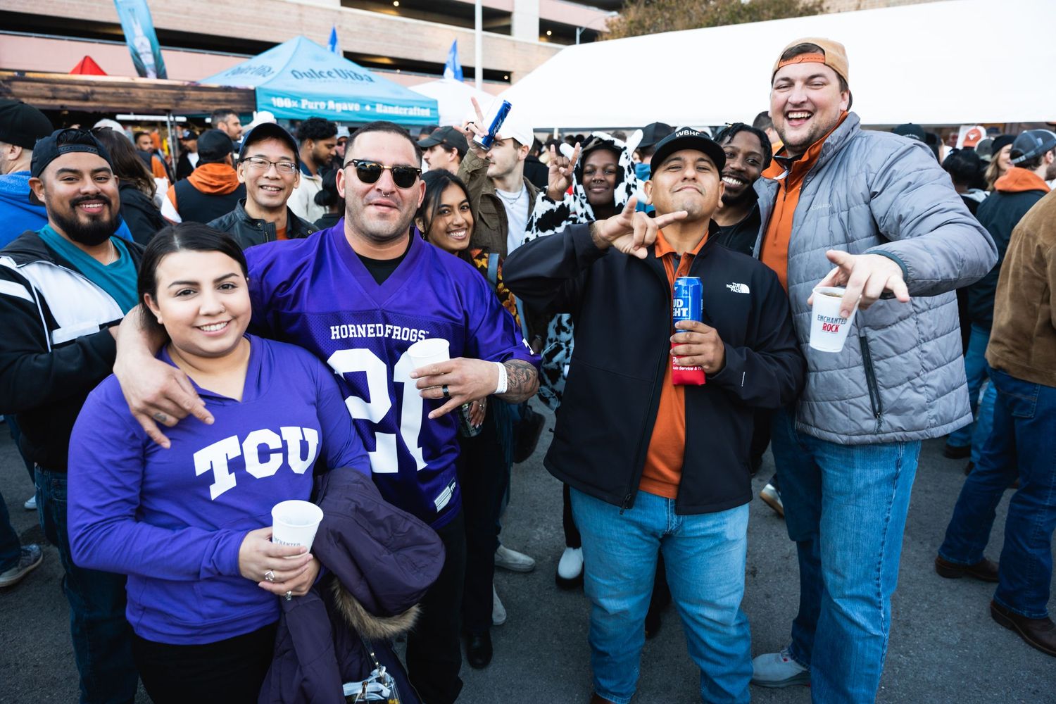 Diverse group of sports fans in TCU gear gathering at an outdoor event.