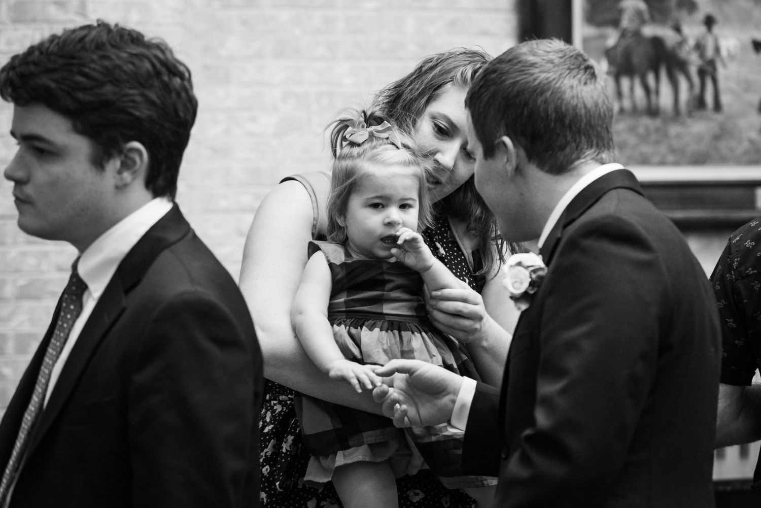 A tender family moment captured in black and white during a wedding reception.