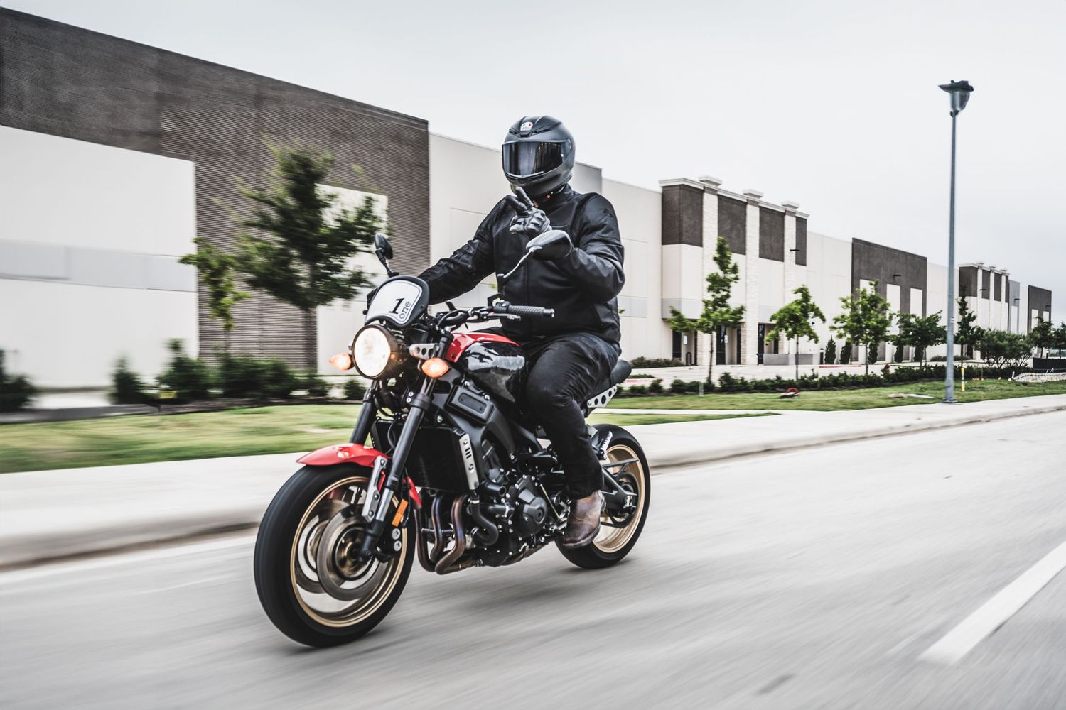 Dynamic view of motorcycle rider navigating through industrial area on powerful street bike.