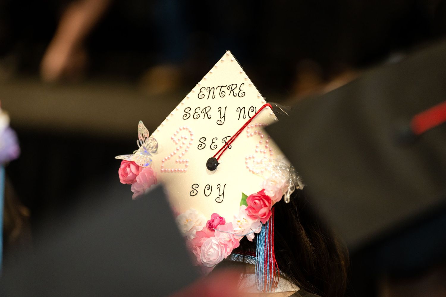 Close-up of a decorated graduation cap with pink flower embellishments.